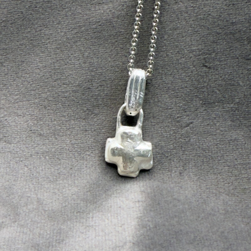 The Crux 001, litet silverkors med rundad form Moonbird
